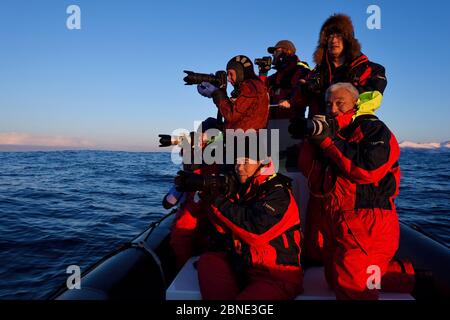 Chinesische Walbeobachtungs- und Fototouristen mit dem Fotografen Magnus Lundgren und dem Führer Henrik Jorgensen in einem aufblasbaren Schlauchboot Zodiac, nea Stockfoto