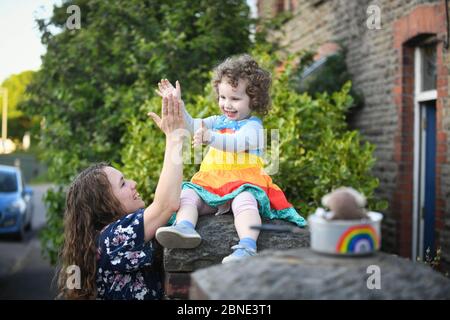 Swansea, Wales, Großbritannien. Mai 2020. Lillian Joy, zwei Jahre alt, und ihre Mutter Bethan, zeigen ihre Wertschätzung für NHS und Key Workers, indem sie während des Claps für unsere Betreuer vor ihrem Haus in Swansea klatschen. Quelle : Robert Melen/Alamy Live News. Stockfoto