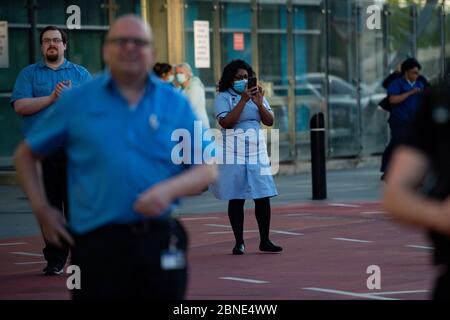 NHS-Mitarbeiter vor dem Queen Elizabeth Hospital in Birmingham, als sie sich dem Applaus anschließen, um lokale Helden während des landesweiten Clap für Betreuer zu begrüßen, um NHS-Mitarbeiter und Betreuer zu unterstützen, die gegen die Coronavirus-Pandemie kämpfen. Stockfoto