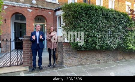 Bildschirmschnappung von Labour-Führer Sir Kier Starmer und seiner Frau Victoria vor ihrem Haus, als sie sich dem Applaus anschließen, um lokale Helden während des landesweiten Clap für Betreuer zu begrüßen, die NHS-Arbeiter und Pförter gegen die Coronavirus-Pandemie anerkennen und unterstützen. Stockfoto