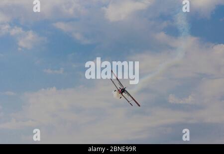 Flugzeug AN-2 in einer Kurve gegen den Himmel mit Wolken. Stockfoto