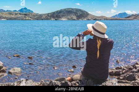 Schöne Frau am Ufer des Sees vor dem Pastoruri Gletscher, im Huascaran Nationalpark, Huaraz / Peru. Stockfoto