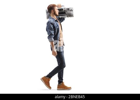 Full length Profil Aufnahme eines Mannes zu Fuß und mit einem Boom-Box-Radio auf seiner Schulter isoliert auf weißem Hintergrund Stockfoto