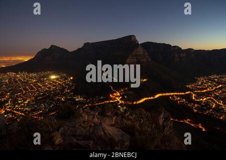 Tafelberg und die Stadt Kapstadt, bei Nacht von Lions Head, Südafrika aus gesehen Stockfoto