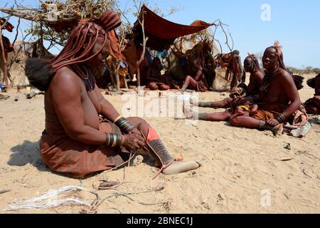 Himba Frau Anpassung ihrer traditionellen "Omohanga" Fuß Ornament, ein 21 Strang geschichteten Fußkettchen, zeigt an, ob sie verheiratet ist und Kinder hat, Marienfluss Stockfoto