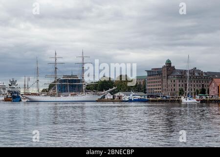 Bergen, Norwegen - 09. September 2019: Großes weißes Segelschiff im Dock auf dem Wasser mit schöner Reflexion in der Nähe historischer Gebäude in Bryggen Kai Stockfoto