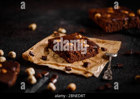 Brownie Kuchen mit Haselnuss und Schokolade auf dunklem Grunge-Tisch Stockfoto