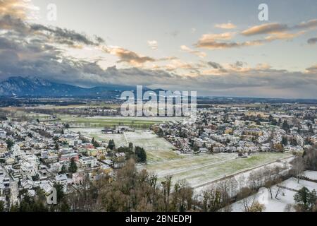 Luftdrohne schoss Blick auf verschneite Dörfer außerhalb Salzburg Outrock während Sonnenuntergang Stunde Stockfoto