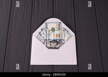 Dollar-Banknoten Geld in weißem Umschlag auf grauem Holzhintergrund Stockfoto