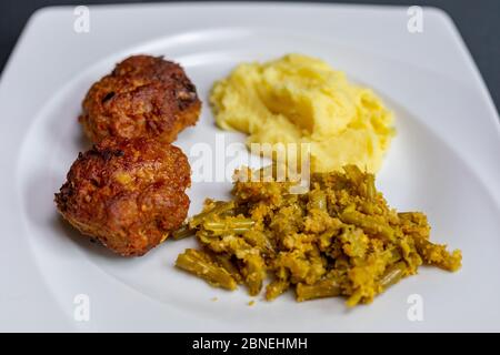 Fleischbällchen, Kartoffelpüree und grüne Bohnen in Teller schließen Stockfoto