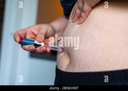 Übergewichtige Frau, die Diabetes Medizin Injektion in ihren Bauch Stockfoto