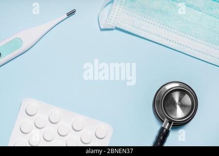 Stethoskop, chirurgische Schutzmaske, Thermometer, Pillen auf blau. Neuartige Coronavirus-Krankheit mit Ursprung in Wuhan, China. Coronavirus Covid-19 pandemi Stockfoto