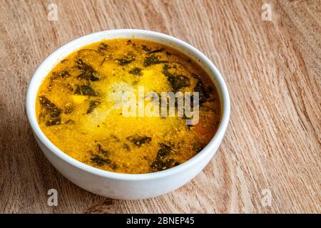 Eine Schüssel Suppe. Suppe aus Kartoffeln, Spinat, Karotten, Fleisch. Nahaufnahme. Stockfoto
