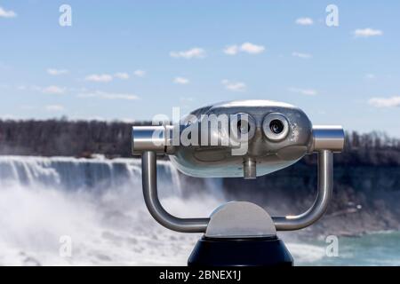 Tourismus münzbetriebene Ferngläser mit Niagarafällen im Hintergrund. Konzept der Wiedereröffnung der Grenze zwischen den USA und Kanada. Stockfoto