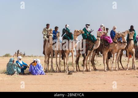 Ingall, Nige Curee Sale festivalr: tuareg Menschen in traditioneller Kleidung sitzen auf Kamelen in der Wüste Stockfoto