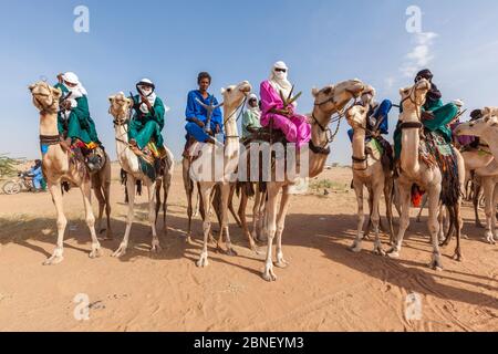 Ingall, Nige Curee Sale festivalr: tuareg Menschen in traditioneller Kleidung sitzen auf Kamelen in der Wüste Stockfoto