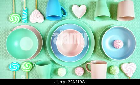Draufsicht auf modernes, in Pastellrosa, grün und blau gedeckter Keramikgeschirr in hellgrün. Kreatives Konzept Kochen, Küche Flatlay Layout. Stockfoto