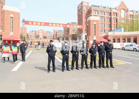 Die älteren Schüler in Qingdao gehen wieder zur Schule und beginnen zum ersten Mal nach der Sperrung den Unterricht wieder. Am Vordertor der Qingdao SCHULE NR. 9, Stockfoto