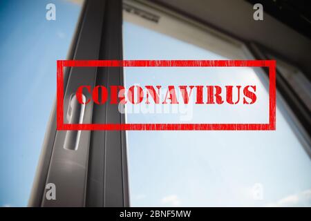 Coronavirus Zeichen und weißen Kunststoff-Fenster mit blauem Himmel Hintergrund, Blick auf außen von zu Hause Isolation Stockfoto