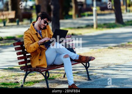 Elegante Geschäftsmann ist in Gespräch, während auf dem Schoß arbeiten Top Stockfoto