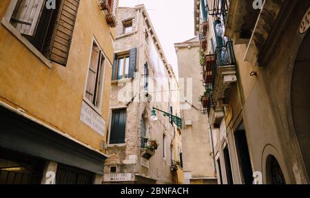 Eine alte Straßenlampe, an der Ecke der Fassade eines Hauses, an einer Straße in Venedig, Italien. Stockfoto