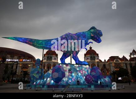Ein riesiges Dinosaurierlicht erscheint auf einem Platz und fällt den vorbeiziehenden Bürgern der Stadt Changzhou, der Provinz Jiangsu in Ostchina, am 19. April 2020 auf. Stockfoto