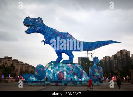 Ein riesiges Dinosaurierlicht erscheint auf einem Platz und fällt den vorbeiziehenden Bürgern der Stadt Changzhou, der Provinz Jiangsu in Ostchina, am 19. April 2020 auf. Stockfoto