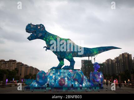 Ein riesiges Dinosaurierlicht erscheint auf einem Platz und fällt den vorbeiziehenden Bürgern der Stadt Changzhou, der Provinz Jiangsu in Ostchina, am 19. April 2020 auf. Stockfoto