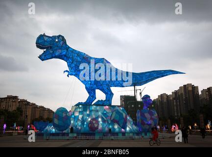 Ein riesiges Dinosaurierlicht erscheint auf einem Platz und fällt den vorbeiziehenden Bürgern der Stadt Changzhou, der Provinz Jiangsu in Ostchina, am 19. April 2020 auf. Stockfoto