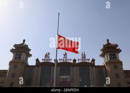 Die chinesische Flagge wird gesenkt, da China nationale Trauer um die Menschen aushält, die am 4. April 2020 in Peking an dem Coronavirus gestorben sind. Stockfoto