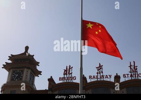 Die chinesische Flagge wird gesenkt, da China nationale Trauer um die Menschen aushält, die am 4. April 2020 in Peking an dem Coronavirus gestorben sind. Stockfoto