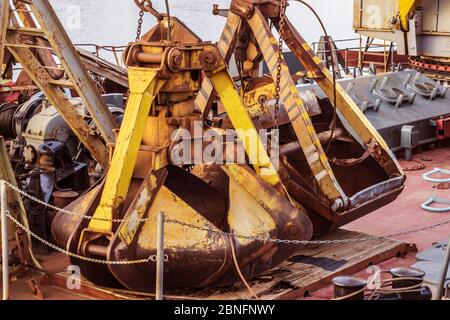 Alte rostige Baggerkübel auf dem Deck eines Flussschiffes Stockfoto