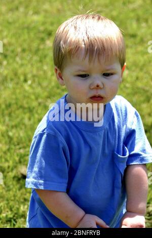 MEMPHIS, VEREINIGTE STAATEN - Apr 21, 2007: Kleiner Junge Kleinkind steht auf, nachdem er Nase draußen im Gras kratzt. Stockfoto