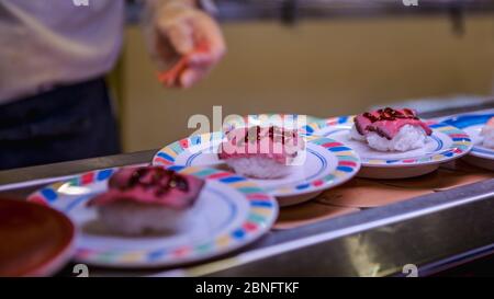 Sushi auf Förderband in einem japanischen Restaurant. Traditionelle japanische Küche von Kaitenzushi. Shushi Go Round ist eine berühmte Form des Fast Food in Asien, auch bekannt Stockfoto