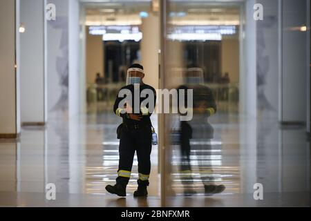 Bangkok, Thailand. Mai 2020. Ein Feuerwehrmann geht an einem Schaufenster im Einkaufszentrum Siam Paragon vorbei.nach zwei Monaten Thailand-Abschaltung aufgrund der Covid-19-Krise. Die Einkaufszentren werden am 17. Mai mit strengen Gesundheits- und Sicherheitsmaßnahmen wieder für die Öffentlichkeit zugänglich gemacht. Quelle: SOPA Images Limited/Alamy Live News Stockfoto