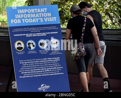 Orlando, Usa. Mai 2020. Ein Schild, das die Anforderungen an Gesichtsbedeckungen, Temperaturkontrollen und soziale Distanz erklärt, begrüßt die Gäste, wenn sie sich dem Eingang zum Universal Orlando's CityWalk nähern. Teile des Unterhaltungs- und Einkaufsviertels wurden heute zum ersten Mal seit der Schließung von Universal Orlando am 15. März 2020 wegen der Coronavirus-Pandemie für begrenzte Öffnungszeiten eröffnet. Die Freizeitparks von Universal sind bis mindestens Mai 31 geschlossen. Quelle: SOPA Images Limited/Alamy Live News Stockfoto