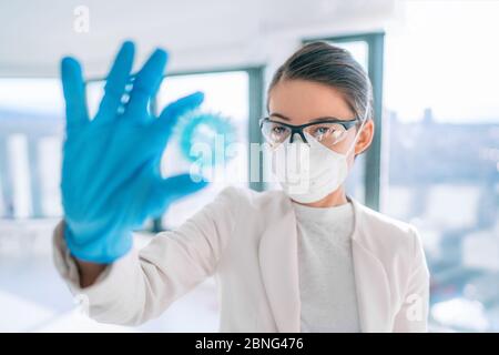 Coronavirus Laborforscherin, die Impfstoff-Heilung findet, die das blaue Modell des Corona-Virus von COVID-19 hält. Stockfoto