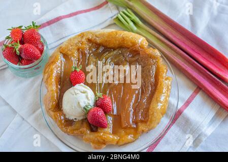 Rhabarber umgedrehten Kuchen mit Erdbeeren und Eis Stockfoto