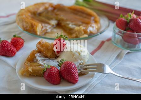 Rhabarber umgedrehten Kuchen mit Erdbeeren und Eis Stockfoto