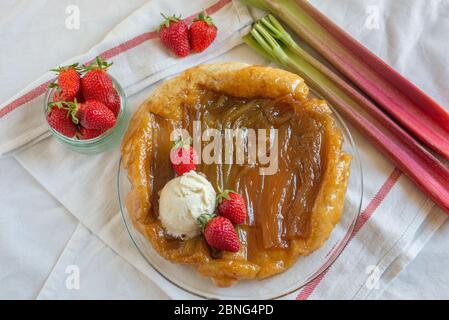 Rhabarber umgedrehten Kuchen mit Erdbeeren und Eis Stockfoto