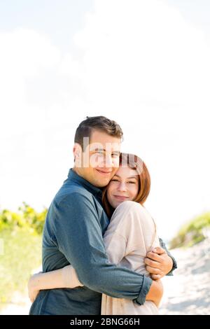 Porträt eines glücklichen Paares, das am Strand spazieren geht. Stockfoto