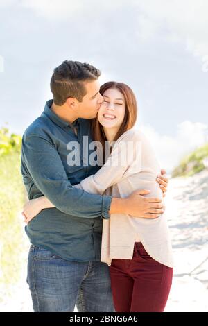 Porträt eines glücklichen Paares, das am Strand spazieren geht. Stockfoto