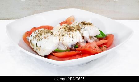 Caprese-Salat mit marinierten Sardinen. Zutaten: Tomaten, Mozzarella, marinierte Sardinen, Basilikum und Origan. Stockfoto
