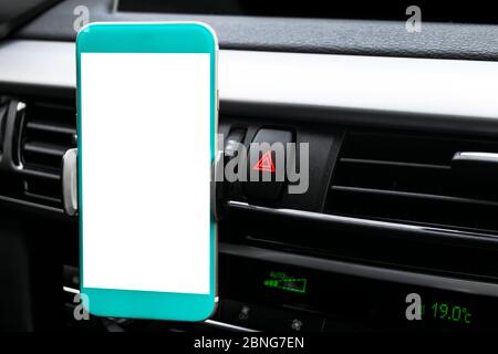 Smartphone in einem Auto für Navigieren oder GPS. Das Fahren eines Autos mit Smartphone im Halter. Mobiltelefon mit isolatede weißer Bildschirm. Leer, leeres Bild.co Stockfoto