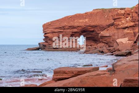 Natürlicher Bogen zwischen Sandsteinfelsen. Küstenerosion an der Nordküste von Prince Edward Island. MacKenzies Brook, PEI-Nationalpark, Kanada. Stockfoto