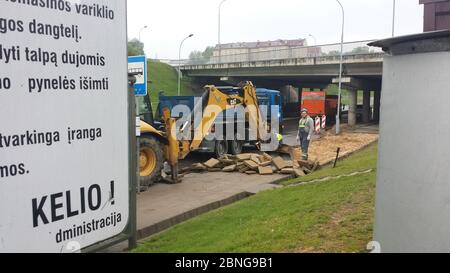 Arbeiter nehmen alte Fliesen vom Bürgersteig Stockfoto