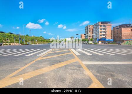 Unter dem blauen Himmel gibt es keine Asphaltstraße am Stadtrand. Stockfoto