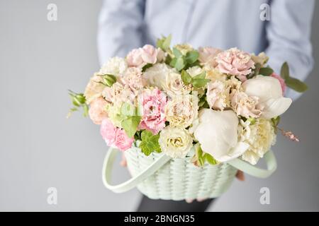 Kleine Blumenladen und Blumenlieferung. Blumenarrangement im Korbkorb. Wunderschöner Blumenstrauß aus gemischten Blumen in der Hand der Frau. Schöner frischer Blumenstrauß. Stockfoto