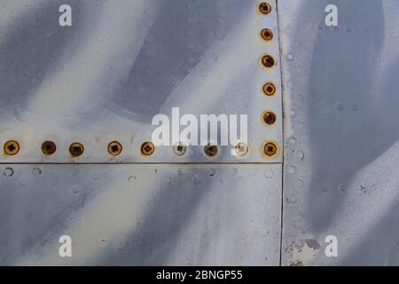 Textur des alten Düsenflugzeugs mit Tiger Tarnung und rostiger Schraube Stockfoto