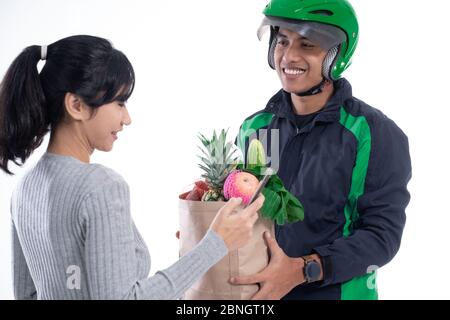 Lebensmittelgeschäft Lieferung. Fahrer Kurier mit Lebensmittel senden Online-Bestellung an weibliche Kunden isoliert über weiß Stockfoto